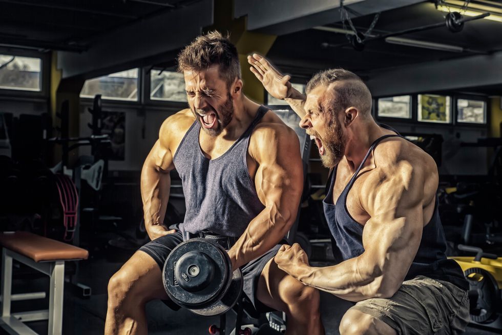 Muscular Men Screaming While Exercising In Gym