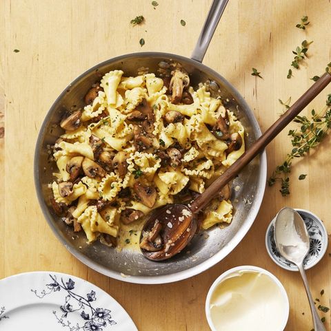 mushroom and thyme campanelle in a pan with a wooden spoon