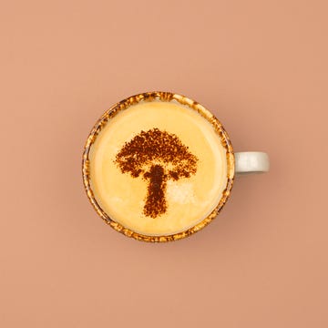 Hoe gezond is mushroom coffee? een kopje koffie met een paddenstoel afgebeeld in het schuim