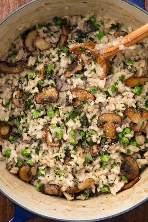 mushroom risotto with peas in a dutch oven with a blue handle
