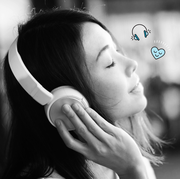 a woman listening to music with white over the ear headphones