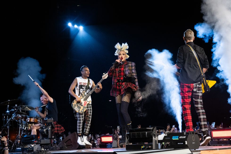 no doubt members adrian young, tony kanal, gwen stefani, and tom dumont perform on a stage at night