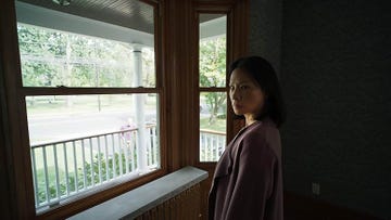 individual gazing out of a window in a house