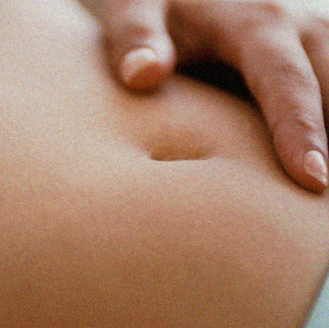 woman rests her hand on her stomach