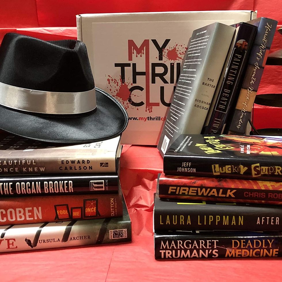 my thrill club book box selections, stacked books