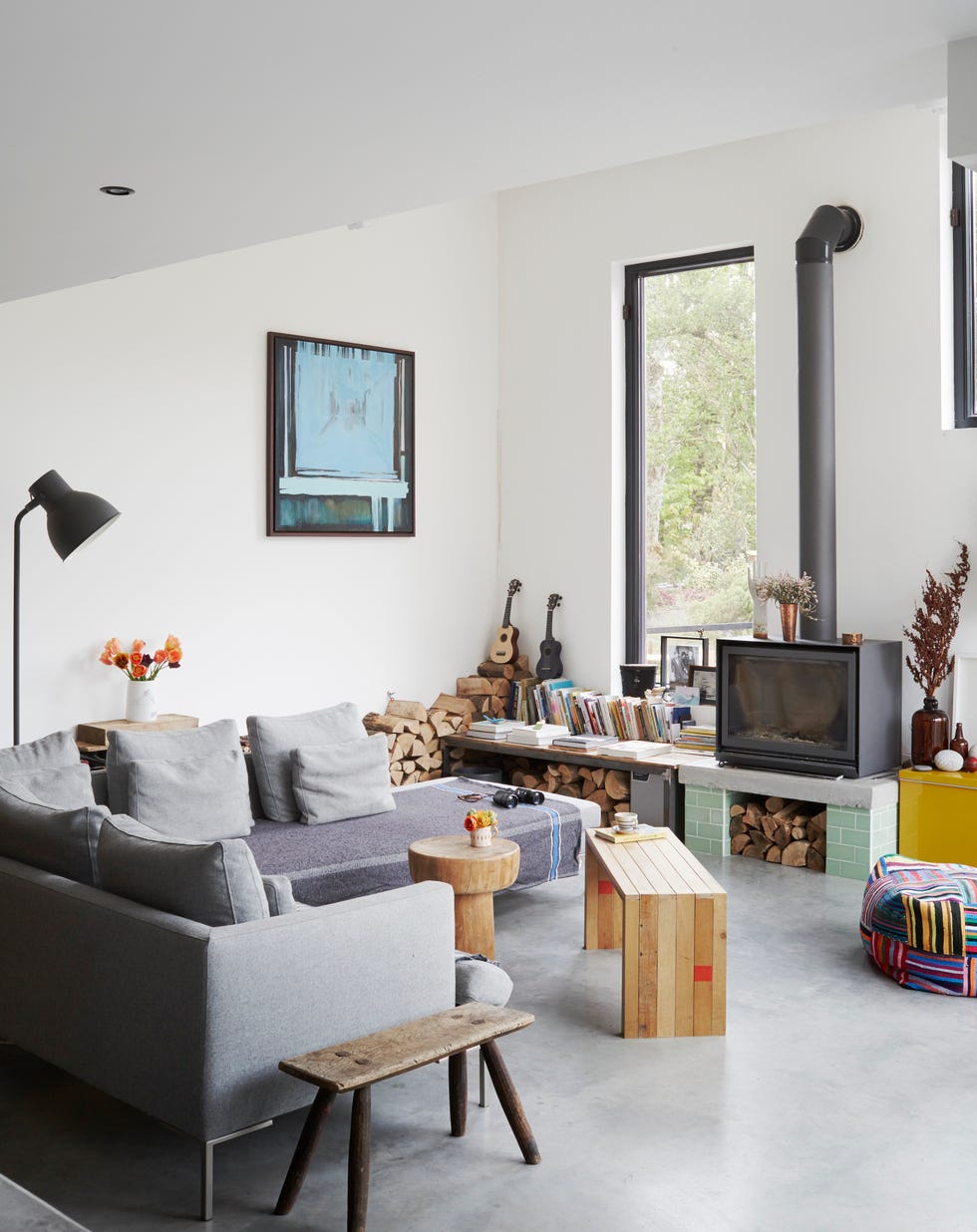 a cosy space in an open plan living area with an l shaped grey sofa and logburner