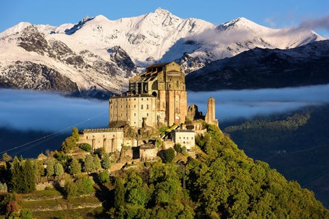 Sacra di San Michele Deze oude abdij werd in de tiende eeuw gebouwd op de top van de Monte Pirchiriano en biedt bezoekers schitterende uitzichten op Turijn en de Val di Susa in de Italiaanse regio Piemonte De hoofdkerk van de Sacra die teruggaat tot de twaalfde eeuw is de laatste rustplaats van de leden van het Huis Savoye een van de oudste koningshuizen ter wereld