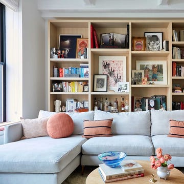 a living room with a white couch and a book shelf