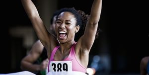 blije vrouw over de finish van de marathon