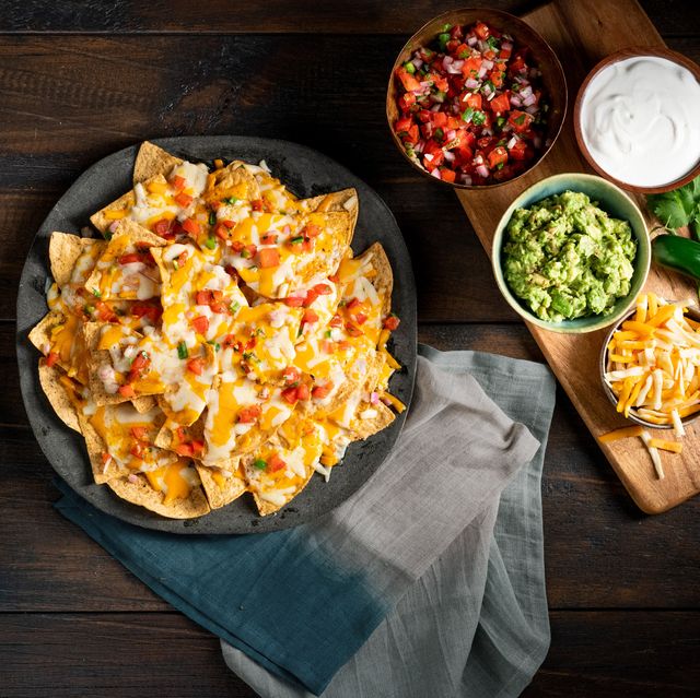 a plate of cheesy nachos with toppings
