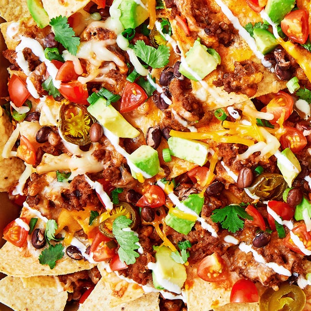 tortilla chips topped with ground beef, tomatoes, avocado, cheese, sour cream, and jalapenos