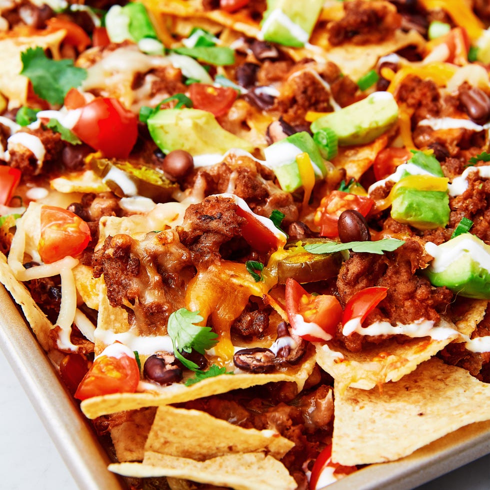 tortilla chips topped with ground beef, tomatoes, avocado, cheese, sour cream, and jalapenos