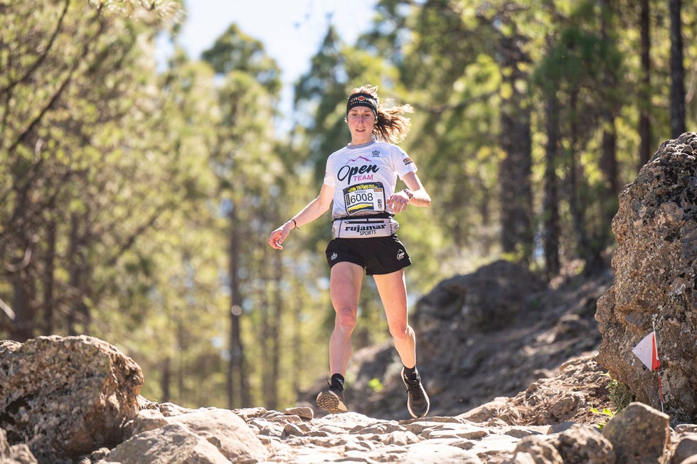 athlete participating in a trail run through a forested area