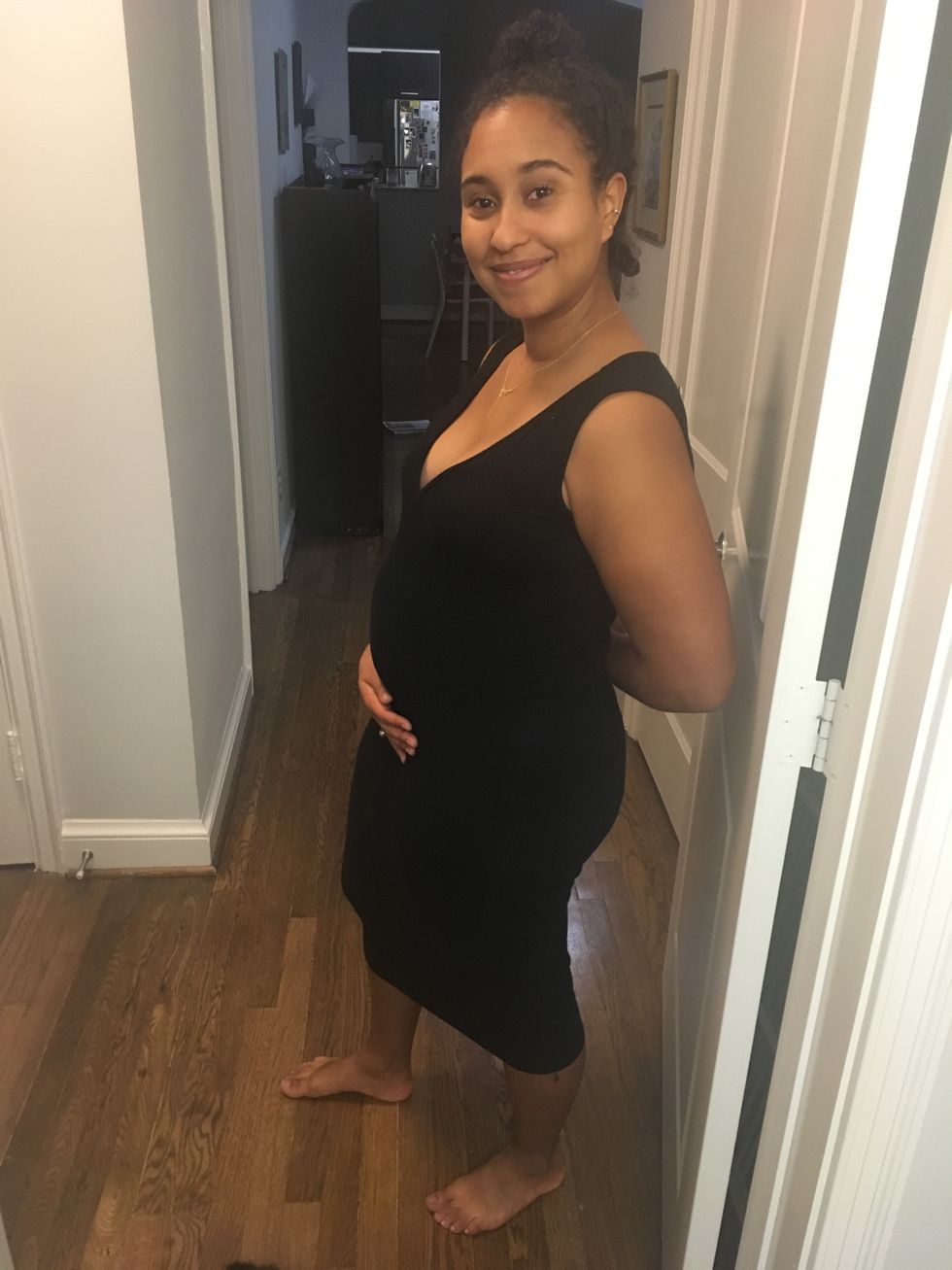 naima coster stands sideways, her pregnancy visible