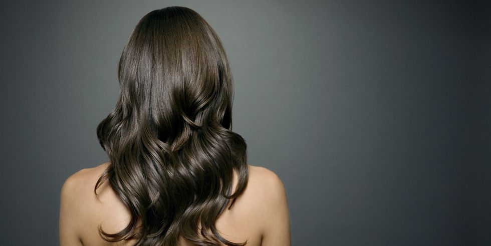 naked woman with long shiny wavy hair, back view