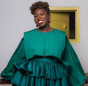 ghanaian author nana darkoa sekyiamah smiling in red lipstick and a teal dress