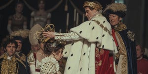 joaquin phoenix as napoleon bonaparte placing a crown on the head of wife josephine played by vanessa kirby