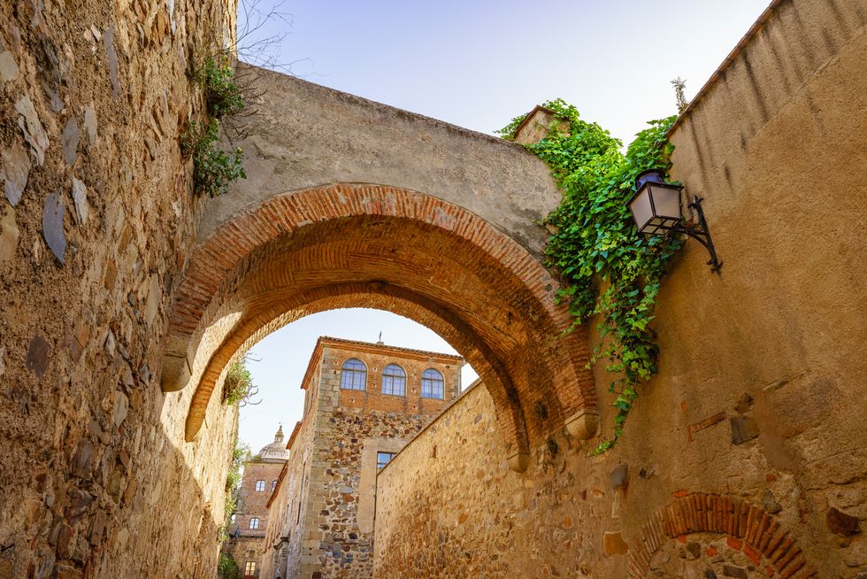 narrow alley with an arch in cáceres