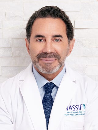 a man in a white coat and blue tie