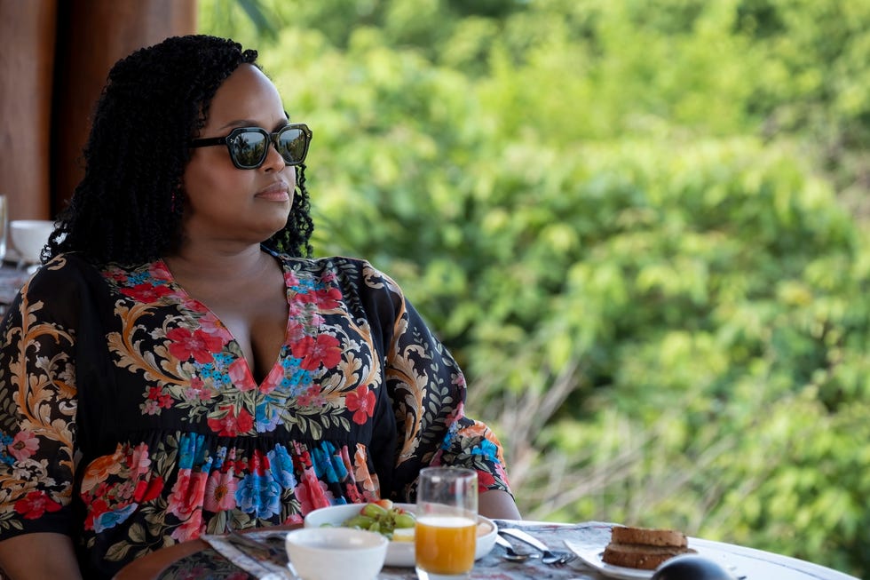 woman sitting at a table wearing sunglasses