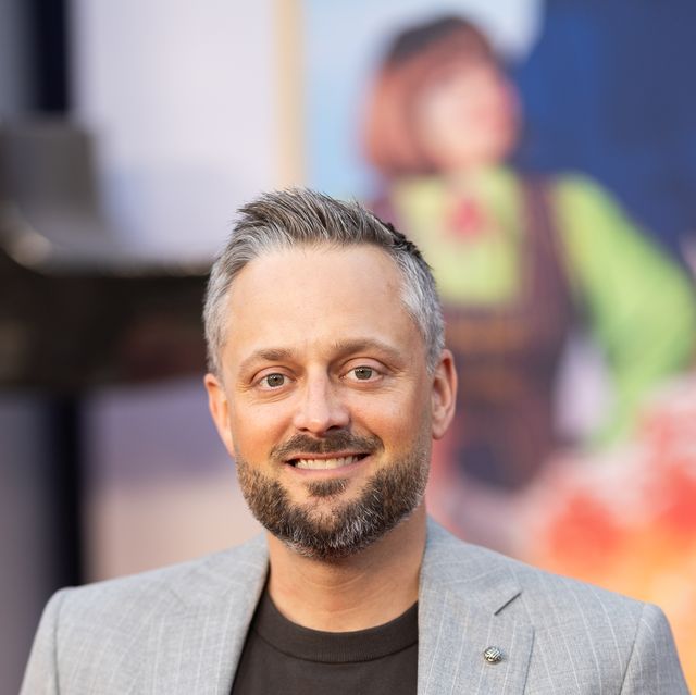 man in a grey suit standing with his hands in his pockets