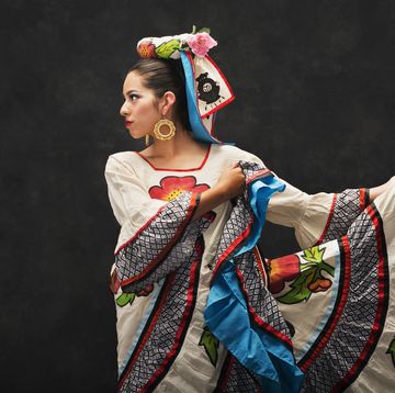 national hispanic heritage month 2023, image of latina woman in traditional mexican dress holding her skirt out to the side