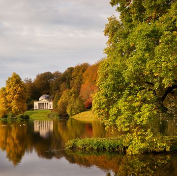in autumn, a view across the lake to the pantheon at stourhead gardens, wiltshire, uk