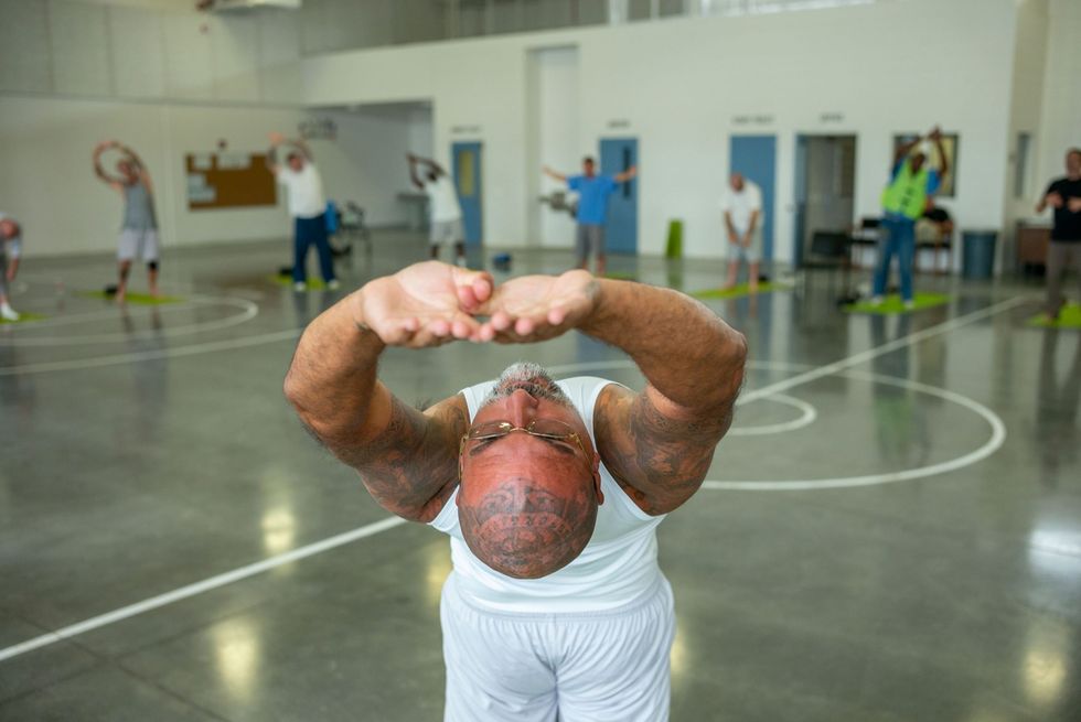 Veroordeelden volgen een yogales in een gevangenis
