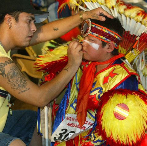 terry st john, of dakota tribe of minnesota, puts make up on the face of rick cleveland, jr, of ho chunk tribe of wisconsin, during the smithsonian's pow wow marking the continuing construction of the national museum of the american indian