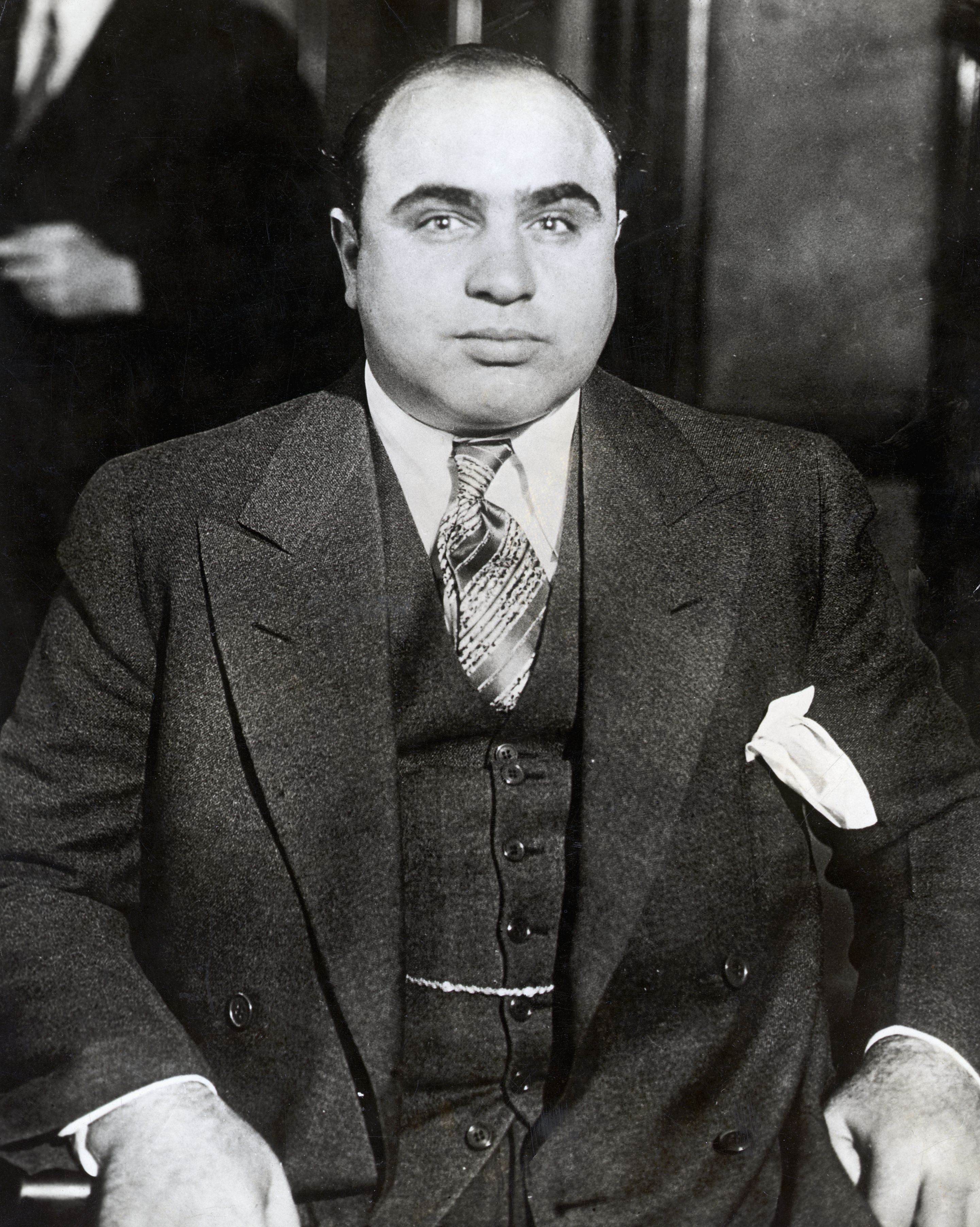 man sitting while wearing a suit and tie