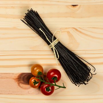 Natural black bean spaghetti on pine background. Ready for cooking