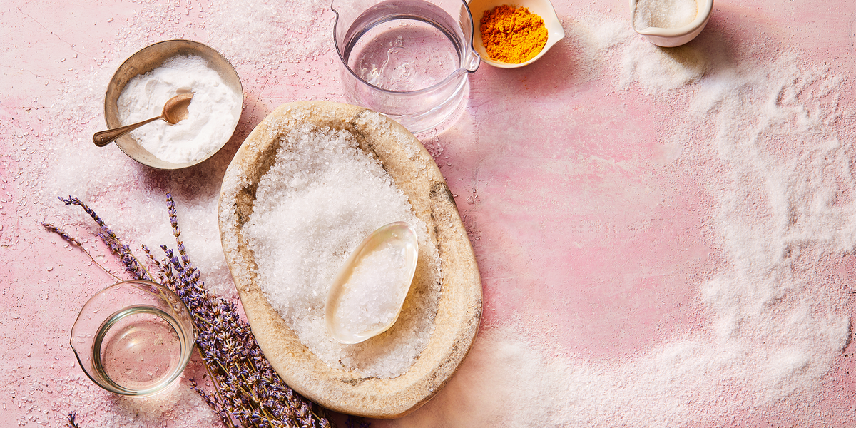 salt, lavender, and turmeric spice sprinkled over pink background