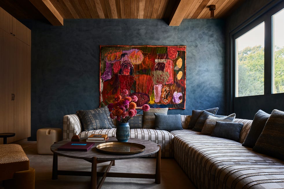 living room with navy blue wall and wood beamed ceiling