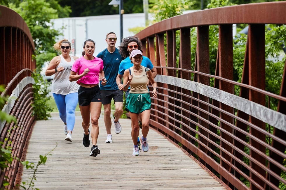 a group of people running on a bridge