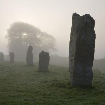 neolithic stone circle in fog at avebury, 