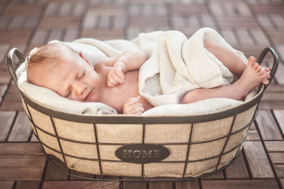 neonato maschio dorme nella cesta