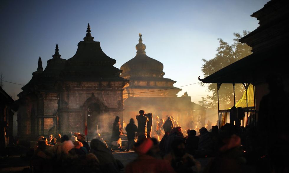Sadhus hebben zich in de avond rond een kampvuur verzameld en roken cannabis bij het Pashupatinathtempelcomplex in Kathmandu Zij zijn gekomen voor het ShivaRatri festival dat hier jaarlijks plaatsvindt ter ere van de god Shiva