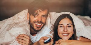 couple watching tv in bed