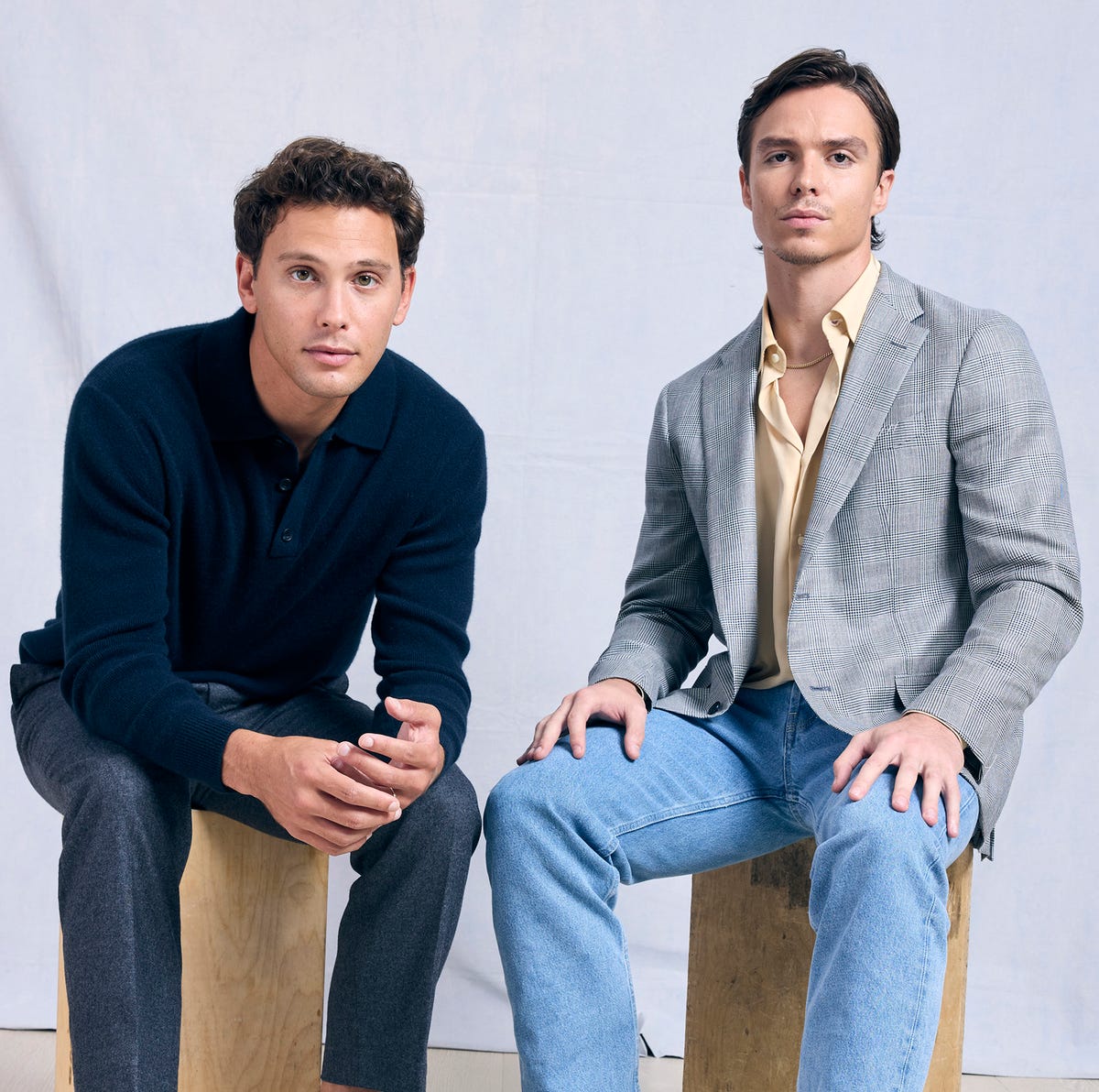 Cooper Koch and Nicholas Alexander Chavez, circa 2024 two men sit on wooden blocks and star at the camera