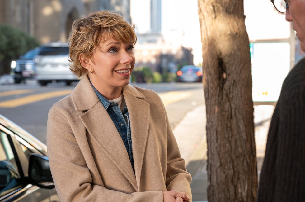 Mary Elizabeth Ellis as Emily stands by a tree and talks to another person in a scene from the Netflix series “A Man On The Inside”.