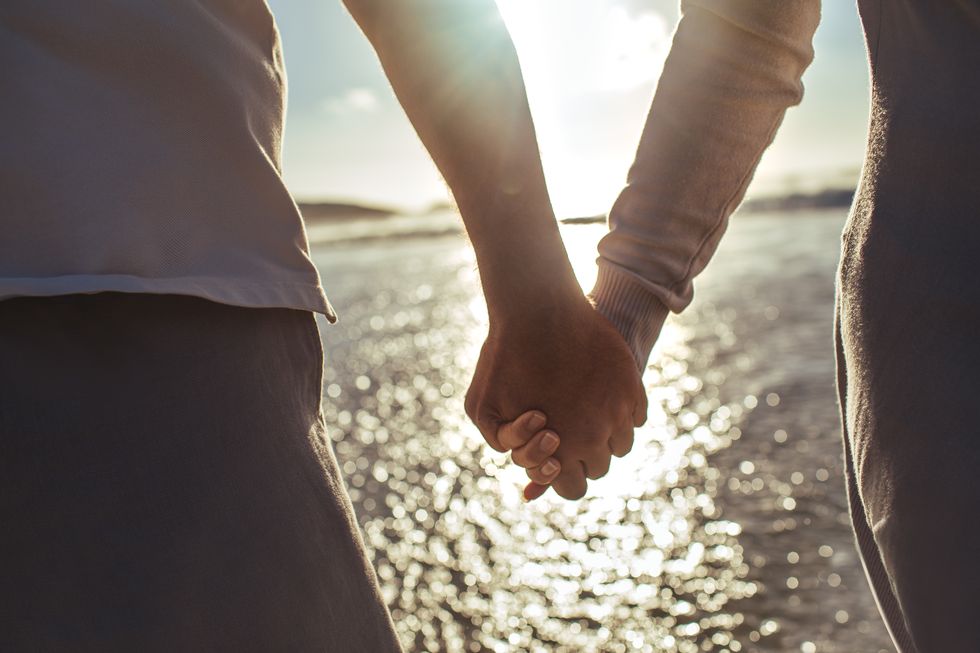 couple holding hands on beach