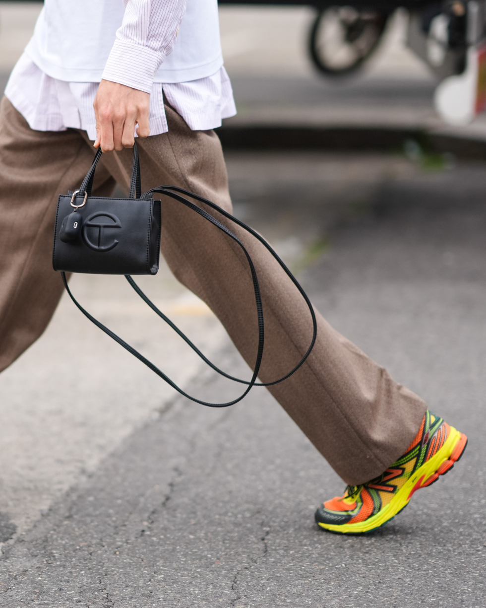 a person walking showcasing a sporty outfit with a stylish handbag