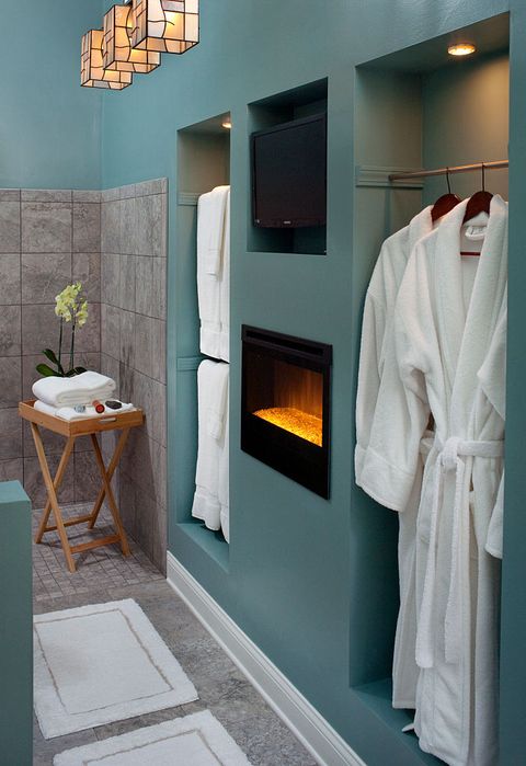 new bathroom with electric fireplace and white robes