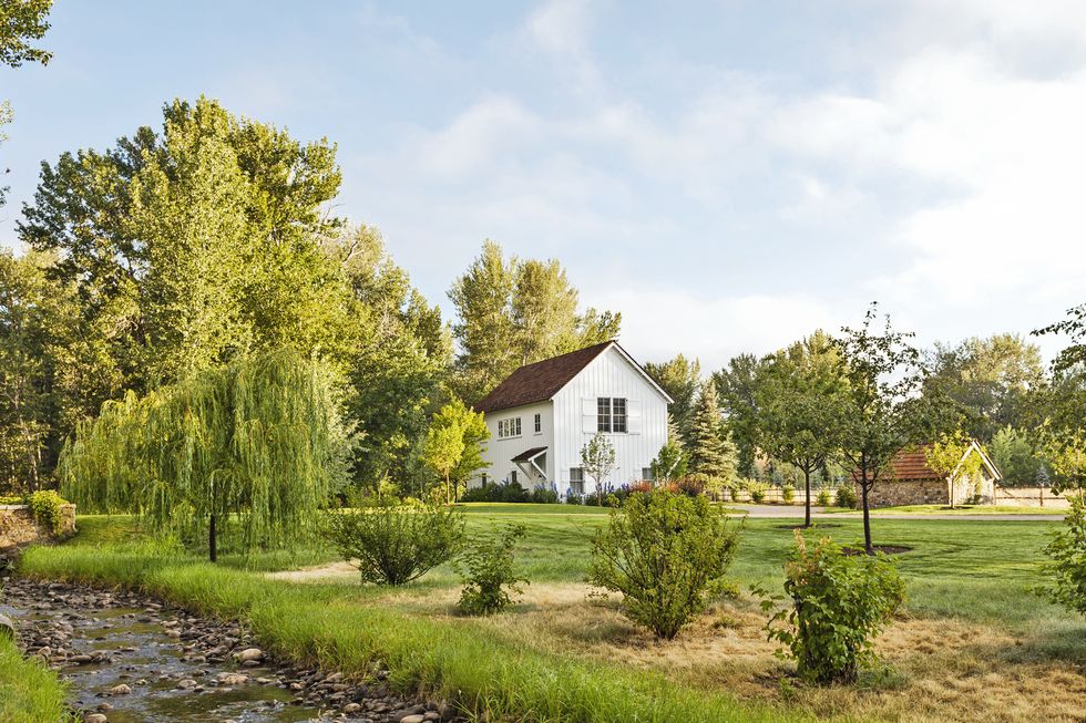 white barn in pastoral setting with stream