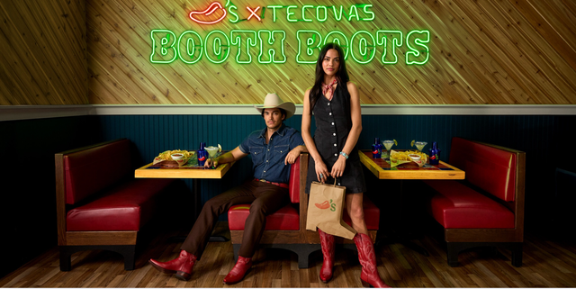 two people in a chili's restaurant wearing red cowboy boots