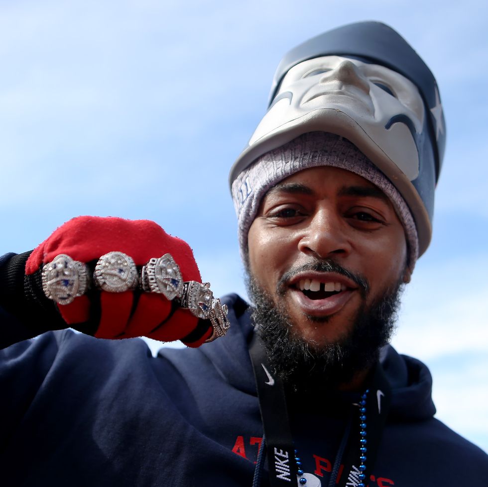 fan with five new england patriots super bowl rings on hand
