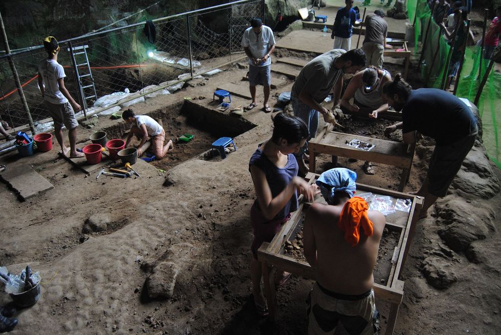 Onderzoekers doen voorzichtig opgravingen in tientallen decimeters dikke klei op deze foto van de werkzaamheden in de Callaogrot in 2011
