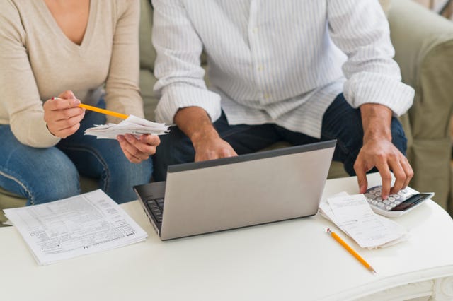 USA, New Jersey, Jersey City, Couple using laptop and calculator