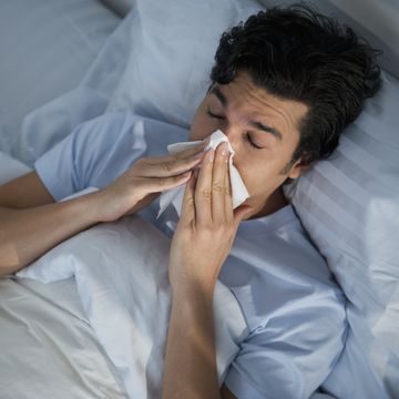 usa, new jersey, jersey city, man lying in bed and blowing nose