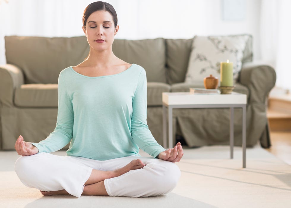 USA, New Jersey, Jersey City, Woman meditating in living room